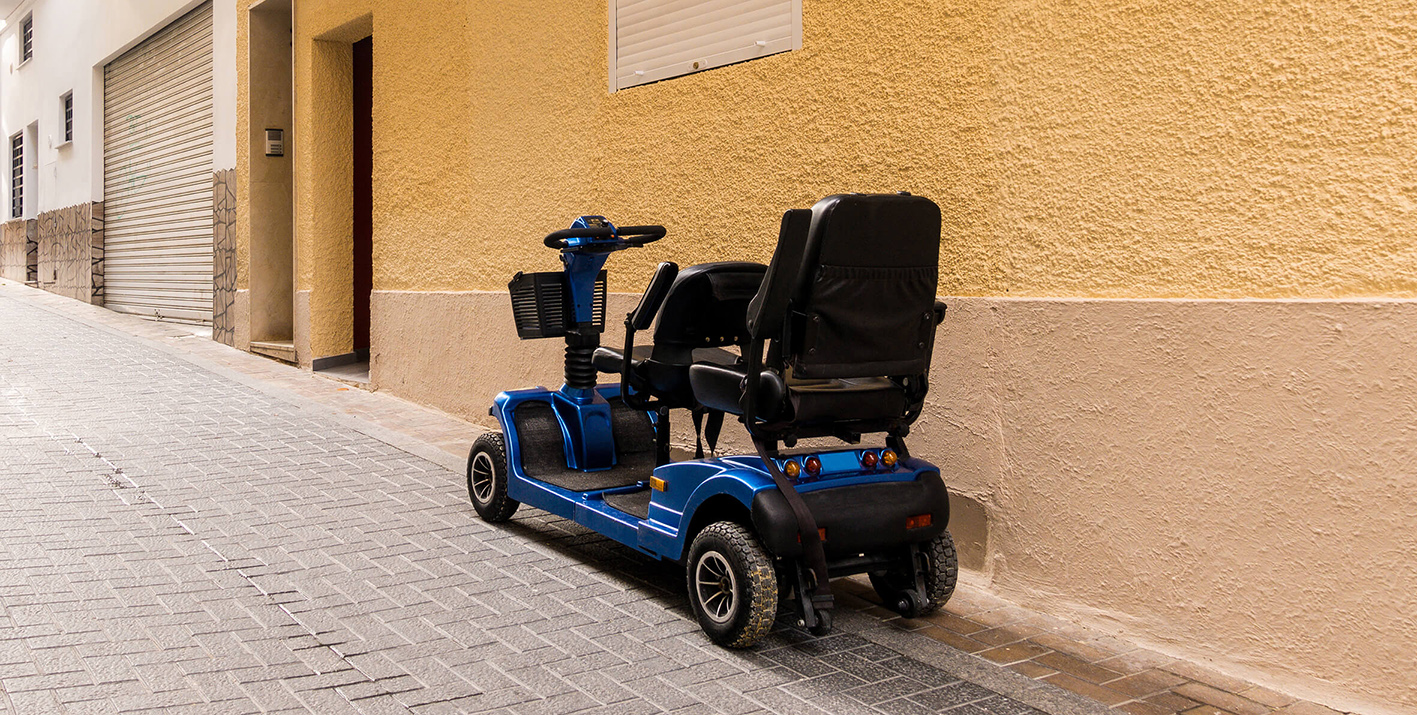 An unattended mobility scooter, parked in a quiet street